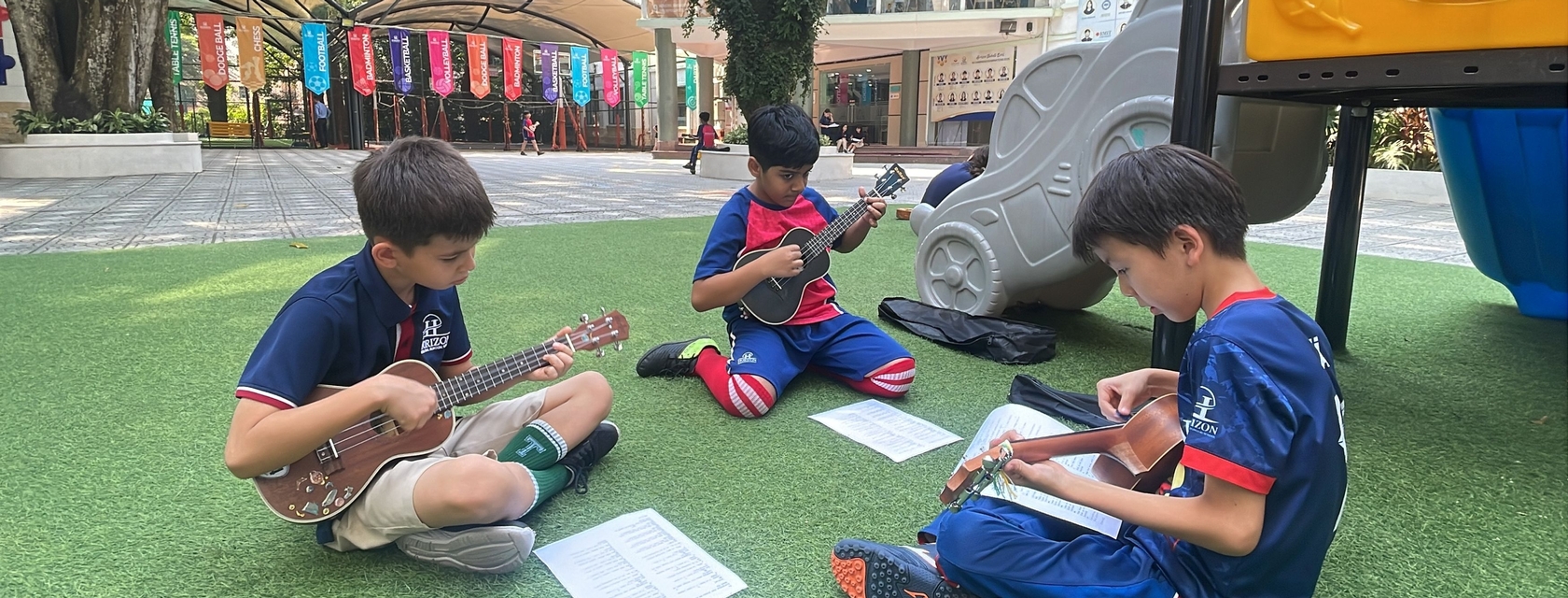 PYP 7 students play ukuleles in Horizon’s sunny schoolyard.